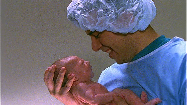 护士把新生儿交给穿着手术服的父亲视频素材