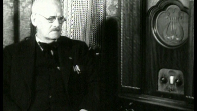 1930年坐在椅子上听收音机的老人/没有声音视频素材