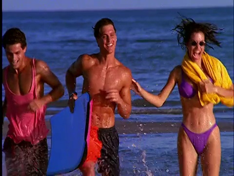 两对穿着泳衣的情侣在海滩上的水里跑步视频素材
