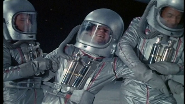 两个穿着太空服的宇航员帮助第三个喝醉的宇航员站起来视频素材