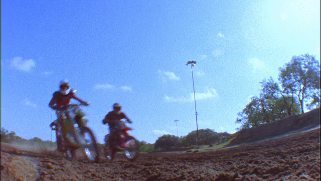 慢镜头低角度3越野自行车超速通过摄像机在泥土视频下载