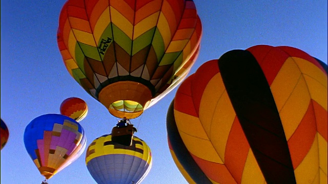 低角度PAN一组色彩鲜艳的热气球上升到蓝色的天空/斯诺马斯，科罗拉多州视频购买