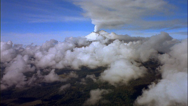 空中鸟瞰云在绿色景观/白色火山在地平线上吹烟视频素材
