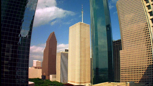 蓝色天空中的低角度延时云+休斯顿市中心摩天大楼的阴影视频素材