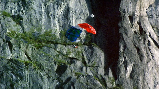 低角度男子从挪威斯塔万格的岩石悬崖上跳伞视频素材