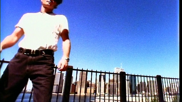 慢镜头低角度的X一代男子踢向摄像机/背景中的纽约天际线视频素材