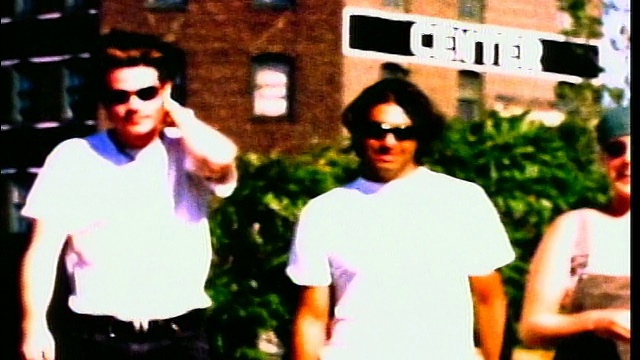 慢镜头2 X世代的男人+女人戴着太阳镜在户外走向相机视频素材