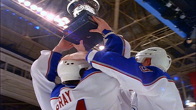 低角度摄影车拍摄约3名冰球运动员举着奖杯骄傲视频购买