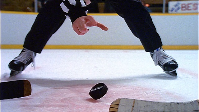 慢镜头低角度近距离的裁判在冰球比赛中丢冰球视频下载