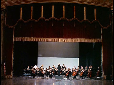 音乐会大厅的宽镜头幕布升起，展示管弦乐队视频下载