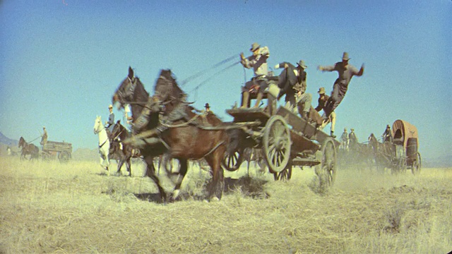 19世纪90年代，人们骑在马背上，马车+四轮马车在平原上疾驰/ 2人从马车上掉下来视频素材