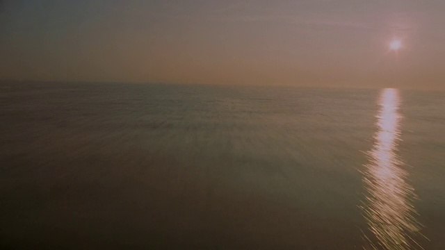 日落时空中飞机的低+快视角视频素材