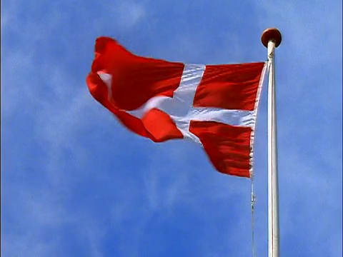 低角红色丹麦国旗在风中飘扬/背景是蓝天/丹麦视频下载