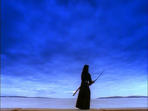 身穿黑色武士服的蓝色女子在海边用剑视频下载
