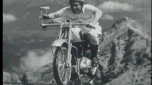 一名骑摩托车的男子在阿尔卑斯山上走钢丝，向镜头挥手视频下载