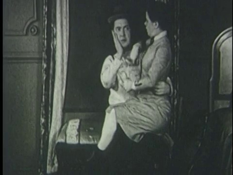 1920年，男人亲吻坐在他腿上的女人(达芙妮·波拉德)，她扇了他一巴掌视频下载