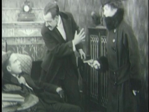1920年，一名女子拿枪指着坐在椅子上的男子，而另一名男子对着他大喊大叫视频下载