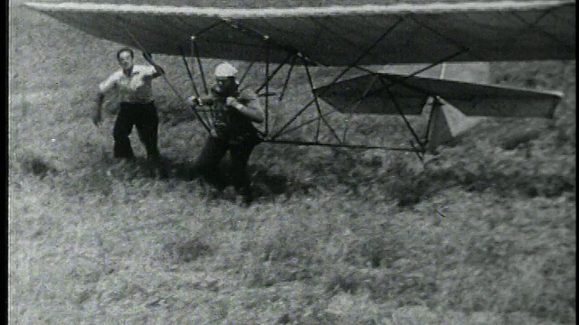 B/W高角度PAN人与早期悬挂滑翔机运行在现场视频下载