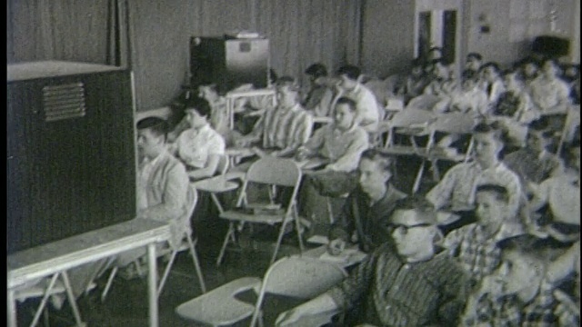 1950年高角度学生坐在课桌前看电视视频下载