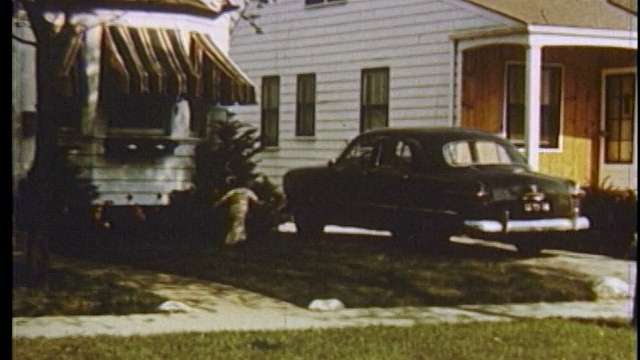 1951年，一名潘人开着黑色福特汽车驶入郊区家的车道/儿子跑过来迎接他/底特律视频下载