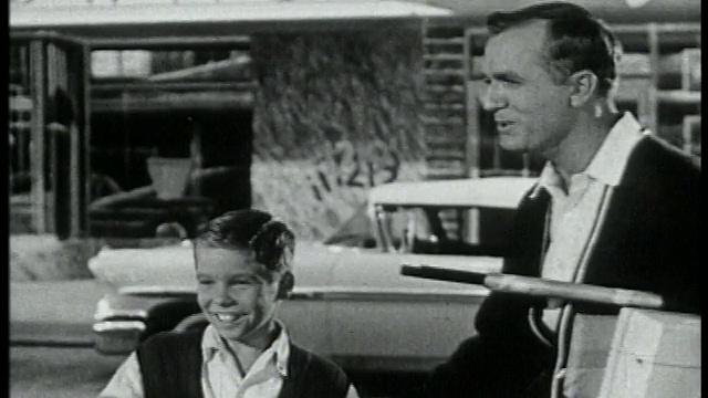 1959年的男孩站在人行道上，父亲也在旁边/他指着+父亲的目光视频素材