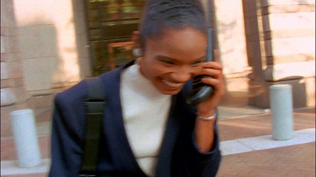 黑人女商人在办公大楼前用手机打电话时大笑视频下载