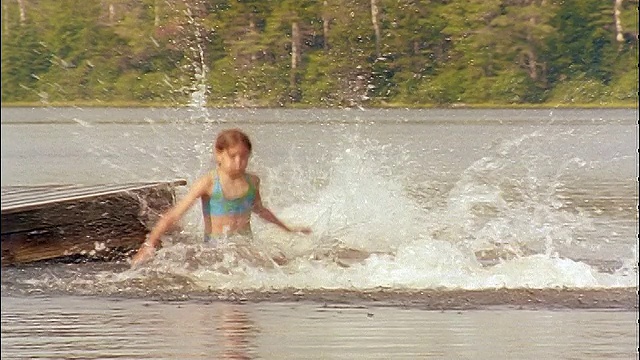 慢动作一组儿童同时从码头跳入湖中视频下载