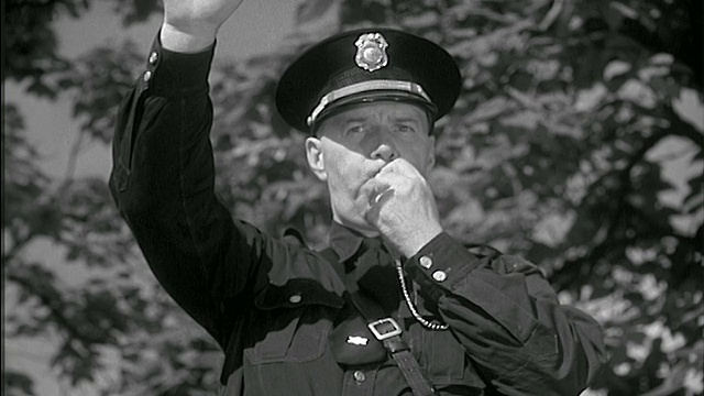 1951年B/W特写警察在街上吹哨子+阻止交通视频下载