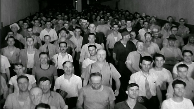 B / W 1944 ?高角度，一大群蓝领工人沿着大厅走向摄像机视频素材
