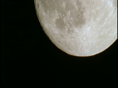 当月球升起时，巨大的陨石坑点缀在月球表面。视频下载