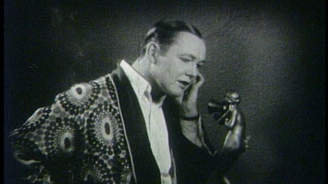 1927年，穿着吸烟夹克的优雅男子(查尔斯·雷)正在打电话视频素材