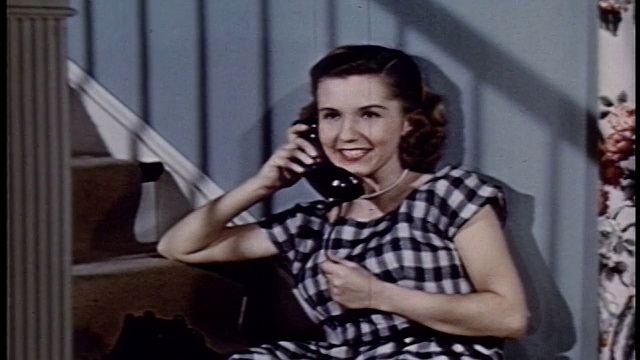 1952年，一位年轻女子坐在楼梯上打电话视频素材