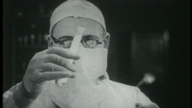 1915年，疯狂的科学家戴着外科口罩，手持带有烟雾的试管视频下载