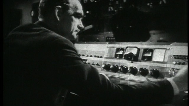 1938年，一名男子在电台播音室的控制室里视频下载
