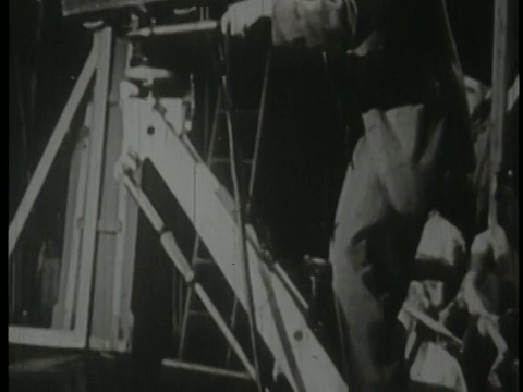 1950年，一名男子在演播室里操作电视摄像机视频下载