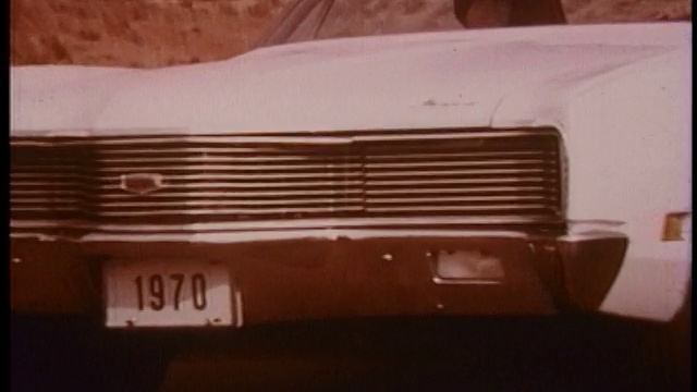 1970年跟踪镜头放大到极端特写白色水星气旋?在沙漠道路上驾驶视频素材