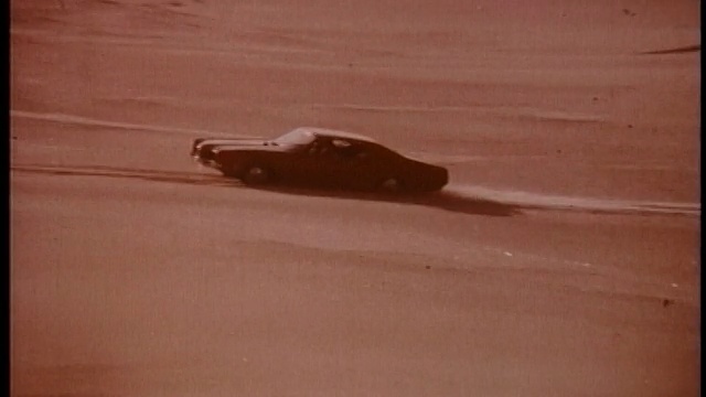 1970年，长镜头水星旋风在沙漠的沙丘上行驶视频下载