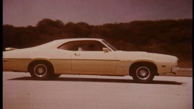 1970年，在高速公路上行驶的黄色水星旋风破坏车被跟踪视频素材