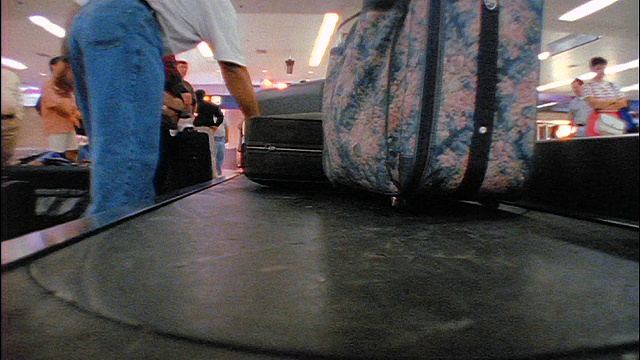 慢动作视角的行李传送带在机场/人从传送带抓取包/奥黑尔机场视频素材