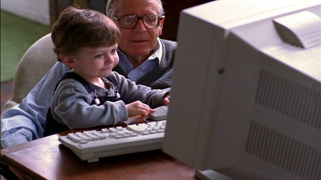小男孩坐在爷爷的腿上玩电脑视频下载