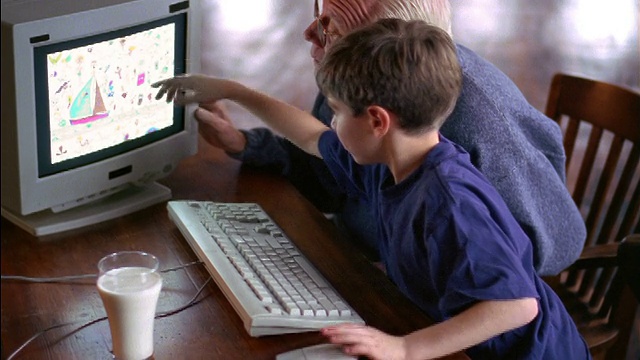 男孩帮助爷爷使用电脑视频下载