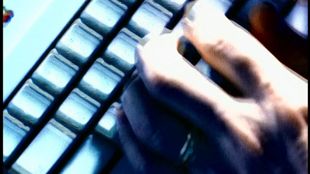 蓝色过度曝光近距离跟踪拍摄的人的手在电脑键盘上打字视频素材
