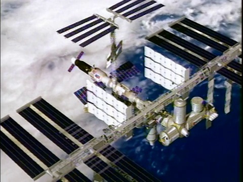 电脑动画显示国际空间站漂浮在外太空/地球为背景视频下载