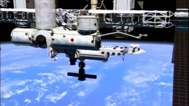 计算机动画制作的国际空间站漂浮在镜头上方，向外太空的地球飞去视频素材