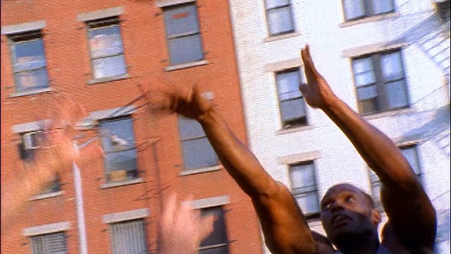 慢动作倾斜两名男子(1名黑人)在户外打篮球/黑人投篮+得分/纽约视频下载