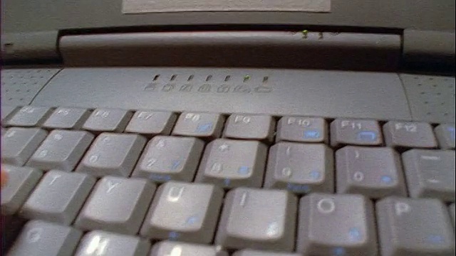 近距离跟踪拍摄的男子的手放置CD ROM到驱动器的笔记本电脑键盘视频下载