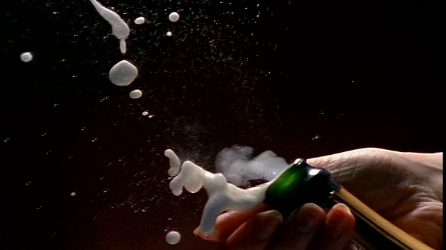 慢镜头拉近了女人的手从香槟酒瓶中弹出软木塞的镜头视频下载