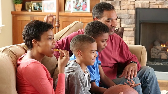 MS家庭和两个孩子在电视上看足球视频素材