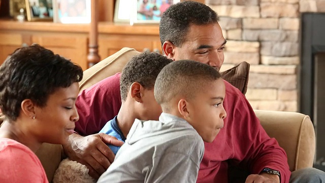 一个家庭和两个孩子在电视上看足球比赛视频素材