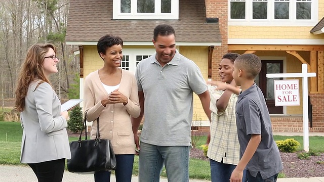 WS幸福家庭握手与房地产经纪人在郊区房子前与出售标志视频素材